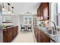 Well-lit kitchen featuring granite countertops, stainless steel sink, wooden cabinetry, and modern lighting fixtures at 2675 Quitman St, Denver, CO 80212