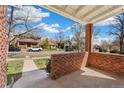 A cozy porch with brick pillars overlooking a street with houses and trees at 2675 Quitman St, Denver, CO 80212