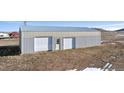 Large detached garage with dual garage doors, offering ample space for vehicles and storage at 12990 Mesa View Rd, Larkspur, CO 80118