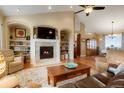 Inviting living room with a cozy fireplace, built-in shelving, and views to the dining area at 34682 Stampede Cir, Elizabeth, CO 80107