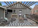 Cozy outdoor patio with a pergola, wicker seating, and a stylish black and white rug at 3327 Irving St, Denver, CO 80211