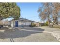 Well-kept home with a gravel yard, charming blue door and a fenced yard at 3385 Olive St, Denver, CO 80207