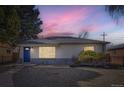 Charming single-story home with a well-maintained yard and lovely curb appeal at dusk at 3385 Olive St, Denver, CO 80207