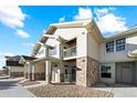 Exterior view of townhome showcasing stone accents, covered entryway, and private balcony at 18633 Stroh Rd # 2-104, Parker, CO 80134