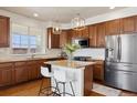 Modern kitchen features a center island, stainless steel appliances, granite counters, and pendant lighting at 9456 Rockhurst St # F, Highlands Ranch, CO 80129