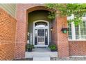 Inviting front entrance with brick archway, decorative door, and potted plants creating a welcoming atmosphere at 6155 Puma Pt, Lone Tree, CO 80124