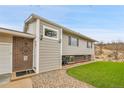 Charming exterior featuring brick accents, freshly cut grass, and a welcoming stone path leading to the front door at 228 Birch Ave, Castle Rock, CO 80104