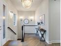 Elegant hallway with hardwood floors, chandelier, decorative table, and staircase at 23030 E Del Norte Cir, Aurora, CO 80016