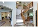 Spacious foyer featuring a hardwood floor, an open staircase, and views into the dining and living rooms at 1313 Iris Cir, Broomfield, CO 80020