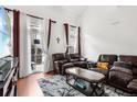 Comfortable living room with plush leather sofas, stylish rug, and bright natural light from a private balcony at 1885 S Quebec Way # G104, Denver, CO 80231