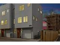 Modern townhome with gray siding, a one-car garage, and a well-maintained exterior at dusk at 3101 W 47Th Ave # 14, Denver, CO 80211