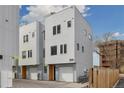 Modern townhome with gray siding, a one-car garage, and a well-maintained exterior at 3101 W 47Th Ave # 14, Denver, CO 80211