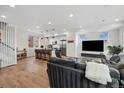 Open-concept living space with a modern kitchen, gray sofa, and an entertainment center beneath bright windows at 3101 W 47Th Ave # 14, Denver, CO 80211