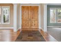 Entryway with stone tile, wood floors, and wooden double doors at 902 Anaconda Ct, Castle Rock, CO 80108