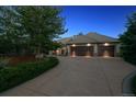 Three-car garage with dark wood doors and a paved driveway at 902 Anaconda Ct, Castle Rock, CO 80108