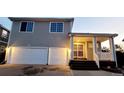 Two-story home featuring a two-car garage and covered front porch with freshly painted doors at 20308 E 48Th Dr, Denver, CO 80249