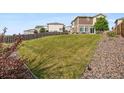 Large backyard with green grass, surrounded by wooden fencing and low maintenance foliage at 242 S Old Hammer Ct, Aurora, CO 80018