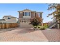 Two-story home with a stone facade, brick driveway and attached two-car garage at 242 S Old Hammer Ct, Aurora, CO 80018