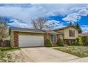 Lovely exterior view of the home showcasing the lush lawn, brick accents, and the driveway at 4640 Fairplay Way, Denver, CO 80239
