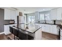Modern kitchen featuring stainless steel appliances, an island with seating, and granite countertops at 4640 Fairplay Way, Denver, CO 80239