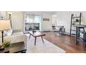 Bright living room featuring hardwood floors and access to a balcony at 3465 S Poplar St # 406, Denver, CO 80224