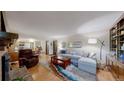 Spacious living room with hardwood floors, comfortable seating, and seamless flow to the dining area at 7865 S Lafayette Ct, Centennial, CO 80122