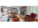 Inviting living room with a brick fireplace, built-in shelves, hardwood floors, and plush seating at 7865 S Lafayette Ct, Centennial, CO 80122