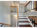 Interior staircase with painted risers and wood treads, plus decorative metal railing at 18056 E Mansfield Ave, Aurora, CO 80013