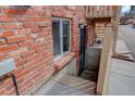 Exterior brick building with window and metal grate door entrance to basement area at 1585 S Holly St # 109, Denver, CO 80222