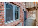 Exterior brick building with window and metal grate door entrance to basement area at 1585 S Holly St # 109, Denver, CO 80222