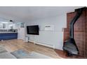 Open concept living room with wood flooring, a fireplace, kitchen, and a TV at 1585 S Holly St # 109, Denver, CO 80222