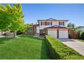 Charming two-story home with a well-manicured lawn and mature tree at 1791 S Laredo St, Aurora, CO 80017