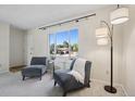 Cozy living area with armchairs, a floor lamp and a large, sunny window at 1791 S Laredo St, Aurora, CO 80017