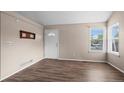 Bright living room with hardwood floors, fresh paint, and natural light from the large window at 3844 S Gibralter St, Aurora, CO 80013