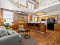 Cozy loft featuring exposed brick, natural wood floors, and a modern kitchen with a bar, creating an inviting space at 225 N Lincoln St # 4, Denver, CO 80203