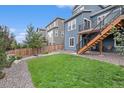 Spacious backyard with manicured lawn, rock landscaping, privacy fence, and elevated porch with stairs at 1168 Basalt Ridge Loop, Castle Rock, CO 80108