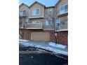 Townhome with attached garage and snow-covered street at 6845 S Webster St # E, Littleton, CO 80128