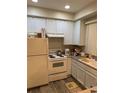Bright kitchen featuring white cabinets and wood-look floors at 6845 S Webster St # E, Littleton, CO 80128