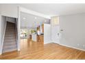 Bright open-concept living space with hardwood floors, staircase to the second level, and white front door at 7970 W 90Th Ave # 115, Broomfield, CO 80021