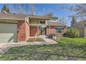 Inviting front entrance with brick accents, a well-kept lawn, and a convenient two-car garage at 6487 W Weaver Ave, Littleton, CO 80123