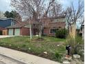 Two-story home with a brick facade, featuring a well-manicured lawn and a convenient two-car garage at 6487 W Weaver Ave, Littleton, CO 80123