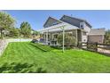 Spacious backyard featuring a lush lawn, patio with pergola, and well-maintained landscaping at 2261 Bulrush Ct, Castle Rock, CO 80109