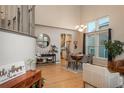 Open-concept dining area features hardwood floors, high ceilings, a dining table and bright natural light with view of kitchen at 781 Deer Clover Cir, Castle Pines, CO 80108