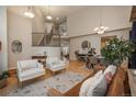 Spacious living room featuring high ceilings, hardwood floors, a staircase, a dining area, and abundant natural light at 781 Deer Clover Cir, Castle Pines, CO 80108