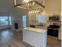 Bright kitchen with stainless steel appliances, an island with white countertops, and modern pendant lighting at 4348 Sable St, Denver, CO 80239