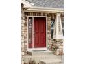 Inviting red front door featuring stone surround and decorative house numbers at 24505 E Wagon Trail Ave, Aurora, CO 80016