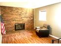 Cozy living room features a brick fireplace and hardwood floors at 19156 E Arizona Pl, Aurora, CO 80017