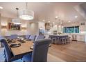 Beautiful dining room open to the kitchen features stylish lighting fixtures, a large table, and ample seating at 17548 Colonial Park Dr, Monument, CO 80132
