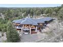 Expansive rear exterior of the home features multiple decks, a hot tub, fenced yard, and wooded surroundings at 17548 Colonial Park Dr, Monument, CO 80132