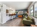 Inviting living room boasts wood floors, a blue accent wall, and stylish seating, seamlessly connecting to the kitchen at 8898 W Harvard Pl, Lakewood, CO 80227
